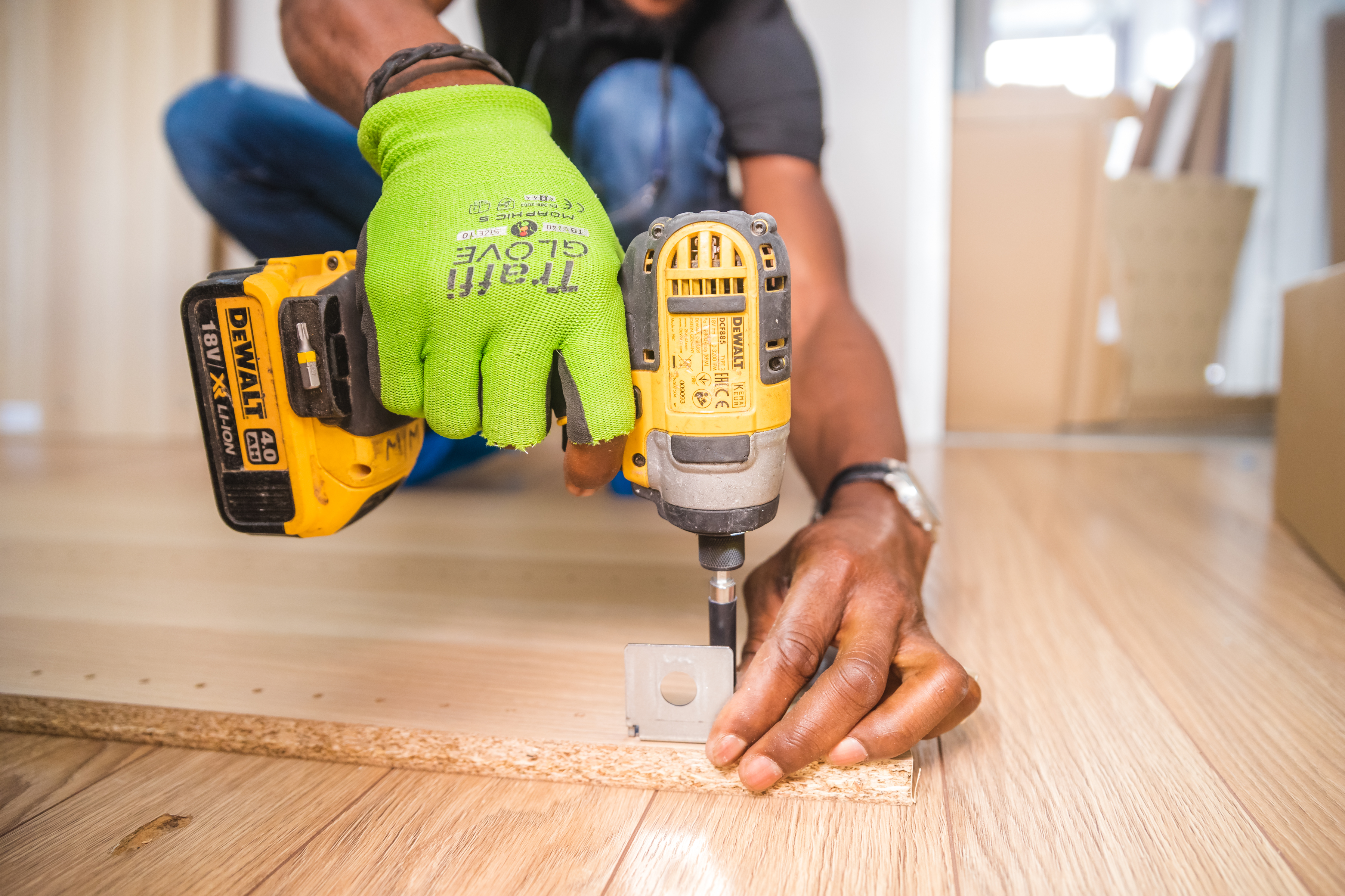 Canva - Person Using Dewalt Cordless Impact Driver on Brown Board